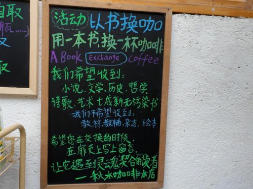 a chalkboard with a book exchange culture on a wall at Autumn Inn in Yangshuo