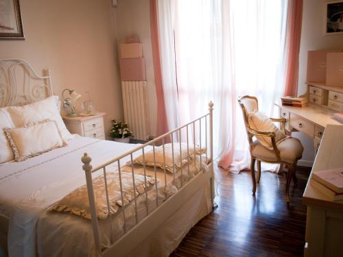 a bedroom with a bed and a desk and a window at Elena's Home in Basiglio