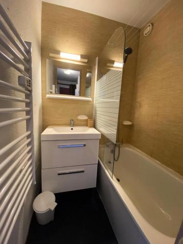 une salle de bain avec un lavabo, une baignoire et un miroir dans l'établissement Studio 4 pers Soleil d'Huez - maeva Home - Studio 4 Personnes Confort MAE-5688, à L'Alpe-d'Huez