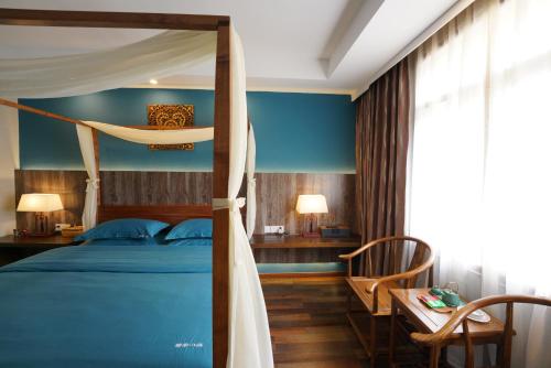a bedroom with a bed and a table and chairs at 九寨沟碧家小筑民宿 Bijia Boutique B&B, jiuzhaigou in Tazang