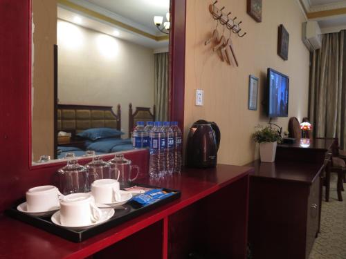 a hotel room with a table with drinks and a mirror at 九寨沟碧家小筑民宿 Bijia Boutique B&B, jiuzhaigou in Tazang