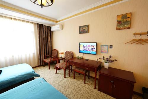 a hotel room with a bedroom with a desk and a bed at 九寨沟碧家小筑民宿 Bijia Boutique B&B, jiuzhaigou in Tazang