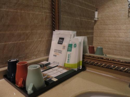 a bathroom sink with a shelf with products on it at 九寨沟碧家小筑民宿 Bijia Boutique B&B, jiuzhaigou in Tazang
