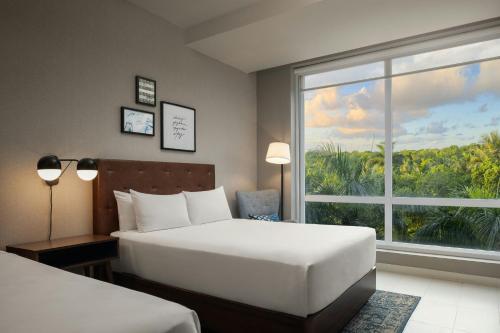 a hotel room with two beds and a large window at Four Points by Sheraton  in Punta Cana