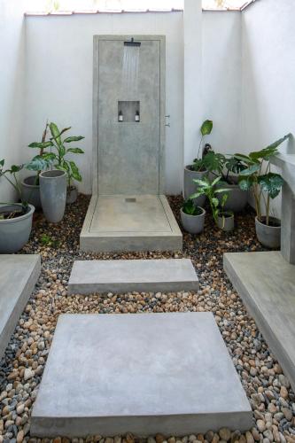 a walkway with a door and some plants at The Well in Ahangama