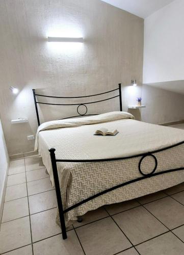 a bedroom with a bed with a book on it at Villetta al mare Sa Babbaiola in Simius