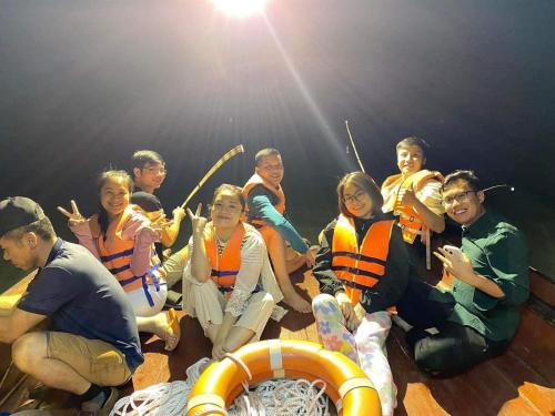 a group of people posing for a picture on a boat at Long Thanh Hotell in Cat Ba