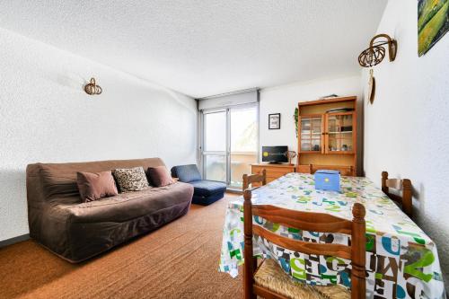 un salon avec un canapé et une table dans l'établissement Les Horizons - maeva Home - Studio 4 personnes - Confort MAE-4161, à La Mongie