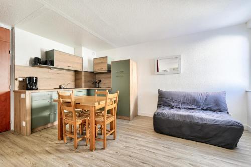 - une cuisine et une salle à manger avec une table et un canapé dans l'établissement Résidence Le Tourmalet - maeva Home - Studio 4 personnes - Prestige MAE-0501, à La Mongie
