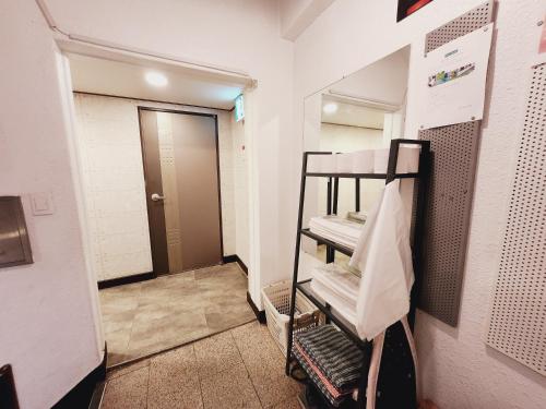 a room with a bathroom with a stack of towels at Olive Hostel MyeongDong in Seoul