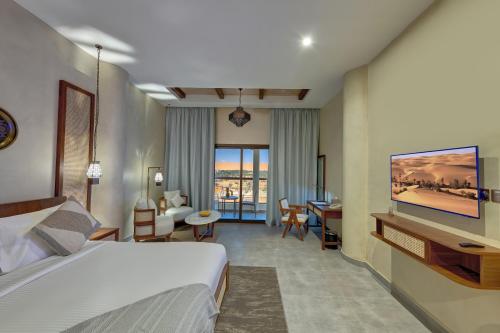 a hotel room with a bed and a living room at Western Hotel Liwa in Liwa