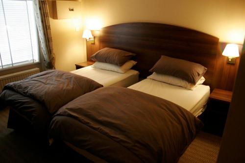 a hotel room with two beds and two pillows at The Railway Tavern Hotel in London