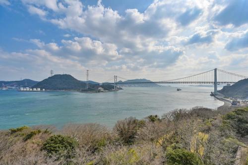 a bridge over a body of water with mountains at Kaikyo View SHIMONOSEKI - Vacation STAY 15379v in Shimonoseki