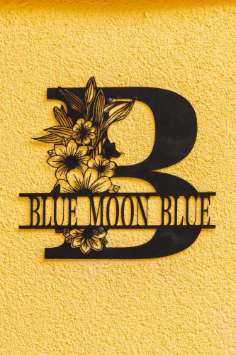 a black sign that says bird moon bridge with flowers at blue moon blue in Ito