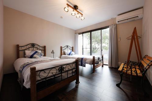 a bedroom with two beds and a large window at blue moon blue in Ito