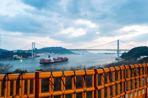 a boat on the river with a bridge in the background at Kaikyo View SHIMONOSEKI - Vacation STAY 13685v in Shimonoseki