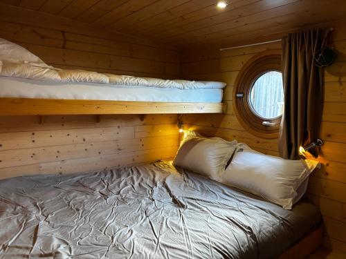 une chambre avec deux lits superposés et une fenêtre dans l'établissement L'erre sauvage, à Blain
