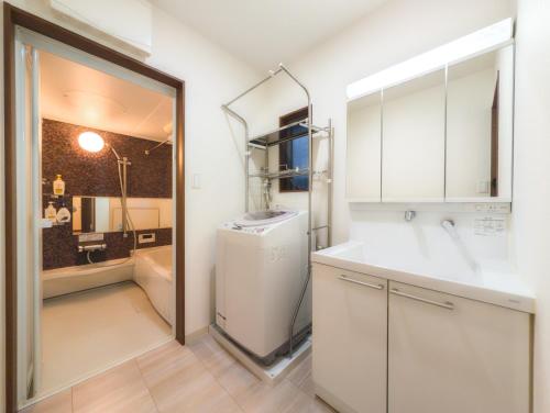 a white kitchen with a sink and a refrigerator at japan house ヴィラ貸切東向島駅5分スカイツリー近く三号館 in Tokyo