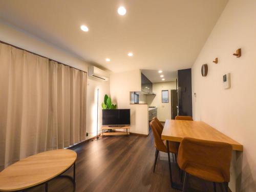 a living room with a table and chairs and a television at japan house ヴィラ貸切東向島駅5分スカイツリー近く三号館 in Tokyo