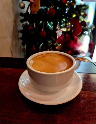 a cup of coffee on a plate on a table at T Zone Hostel - Quiet Place, Near China Town,Ho Thi Ky Street Food,Cafe,Beer in Ho Chi Minh City