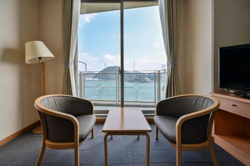 a room with two chairs and a table and a large window at Kaikyo View SHIMONOSEKI - Vacation STAY 13687v in Shimonoseki