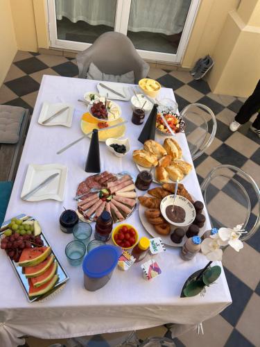 une table blanche avec un tas de nourriture dessus dans l'établissement Somerset Wineland Apartments & Wellness, à Somerset West