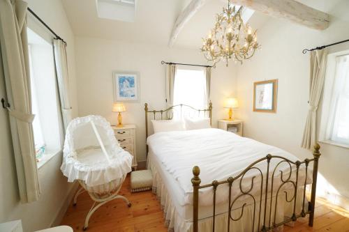a bedroom with a white bed and a chandelier at karuizawa villa Baum in miyota in Miyota