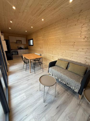 un salon avec un canapé et une table dans l'établissement Petit Chalet neuf avec jardin - La montagne Sud, à Barcelonnette