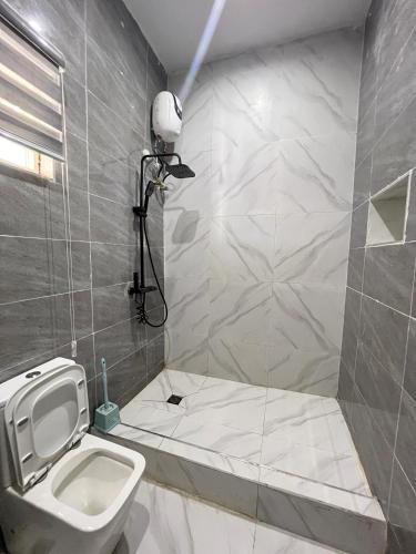 a bathroom with a white toilet and a shower at Home from Home in Ikota