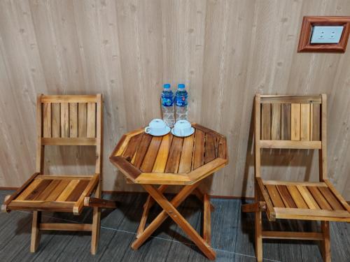 two chairs and a table with two water bottles on it at Green Valley Homestay - Thung Lũng Xanh in Nguyên Ngoại