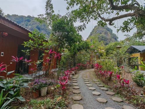 a garden path with flowers and a mountain in the background at Green Valley Homestay - Thung Lũng Xanh in Nguyên Ngoại