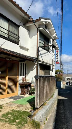 a white house with a table in front of it at Grandma's island Home Hakata - Matsusaki inn 島のおばあちゃんち宿伯方 - 松崎旅館 in Hakata-jima