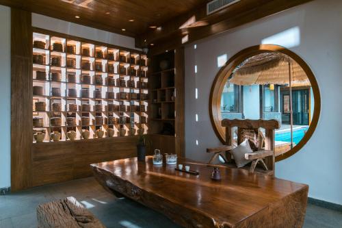 a room with a large mirror and a wooden table at Yueyangli Garden Hotel in Baisha