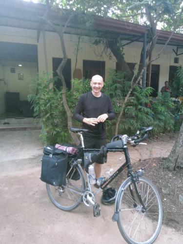 a man is standing next to a bike at Dinimuthu Rest Inn in Wellawaya