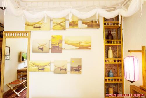 a wall with pictures on it in a room at Hoi An Pho Library Hotel in Hoi An