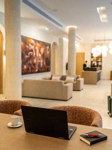 a laptop sitting on a table in a lobby at Hotel Well and Come Málaga in Málaga