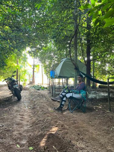 a man sitting in a chair next to a tent at Dragster Tents in Kizhake Chālakudi