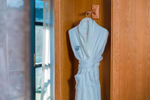 a white dress is hanging on a door at Yueyangli Garden Hotel in Baisha