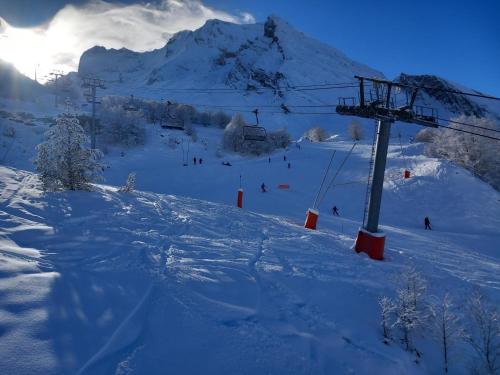 a snow covered ski slope with a ski lift at La Campana 107 in Bielle