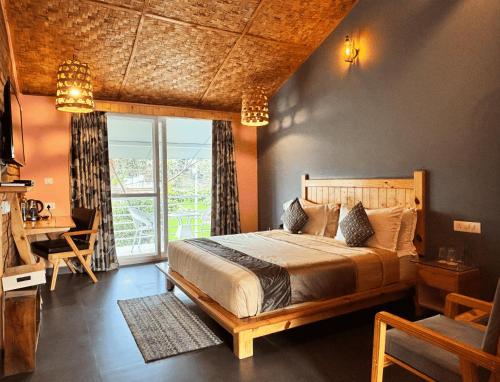 a bedroom with a bed and a desk and a window at juSTa Lazy Haven Corbett, Uttarakhand in Rāmnagar