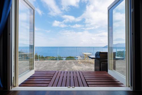 a view of the ocean from the balcony of a house at blue moon blue in Ito