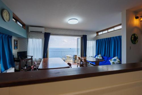 a living room with a view of the ocean at blue moon blue in Ito