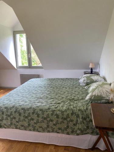 une chambre avec un lit avec une couette verte dans l'établissement La Clémendière, un paradis caché, à Chailly-en-Gâtinais
