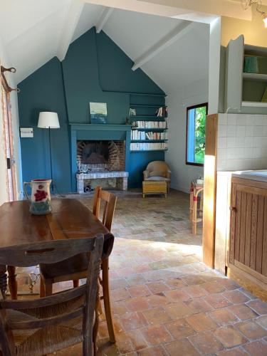 une salle à manger avec une table et une cheminée dans l'établissement La Clémendière, un paradis caché, à Chailly-en-Gâtinais