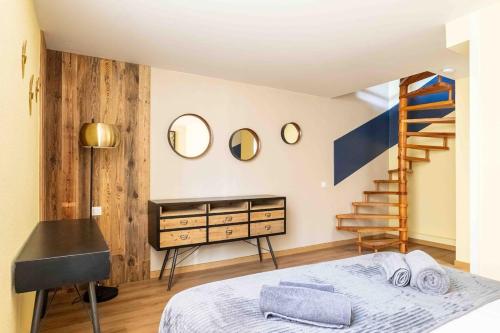 - une chambre avec un lit, un escalier et des miroirs dans l'établissement Le Monnet, à Annecy