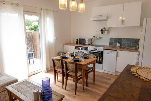 une cuisine avec une table en bois et des chaises ainsi qu'une salle à manger dans l'établissement La Cosy - Sleep in La Ciotat, à La Ciotat