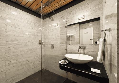a bathroom with a sink and a glass shower at juSTa Lazy Haven Corbett, Uttarakhand in Rāmnagar