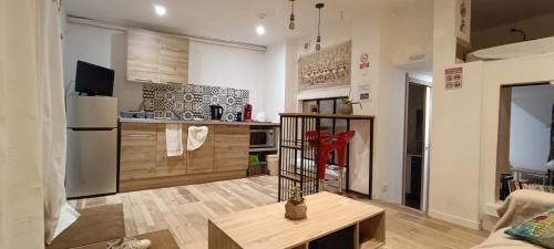 Petit Chalet في سانت كونتان: غرفة معيشة مع مطبخ وطاولة