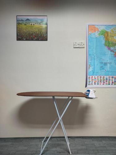 a table against a wall with a map on the wall at Travellers station in Kuantan