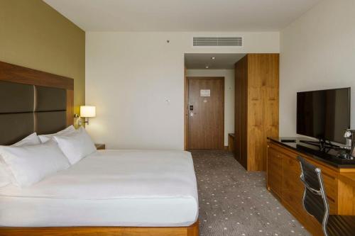 a hotel room with a bed and a flat screen tv at DoubleTree by Hilton Łódź in Łódź